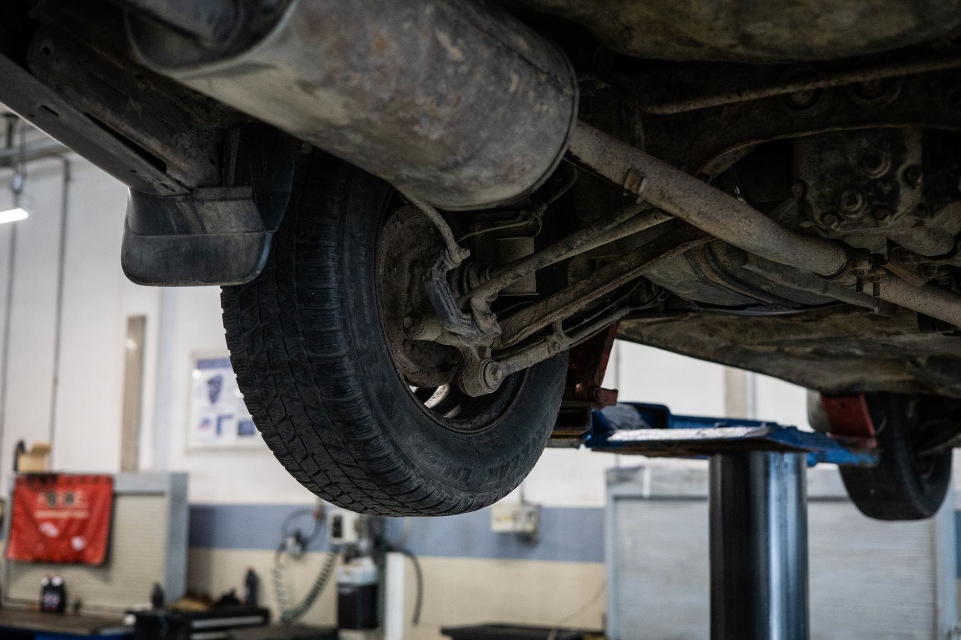 Mechanik ogląda podwozie auta na podnośniku w warsztacie